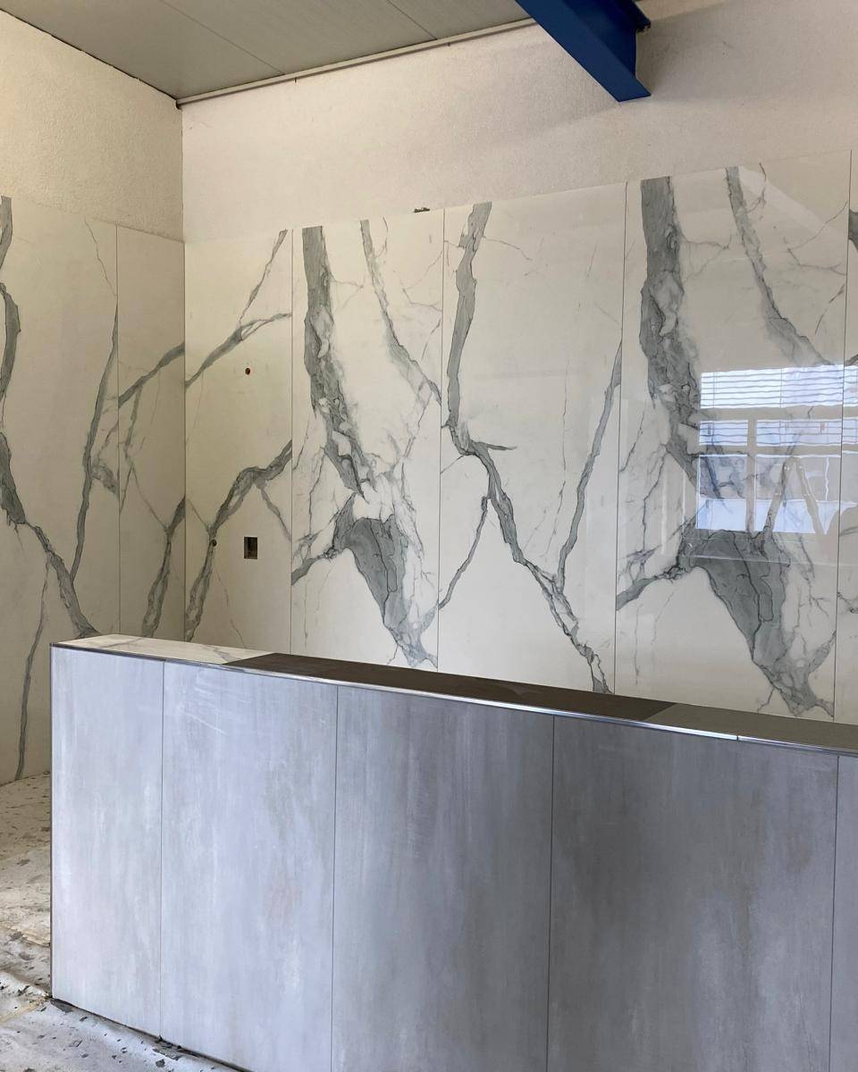 Mur habille en carrelage grand format pose sur 3 metres de haut