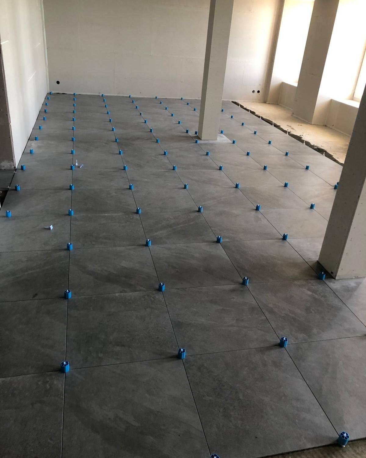 Verification de l'alignement du carrelage en cours de pose