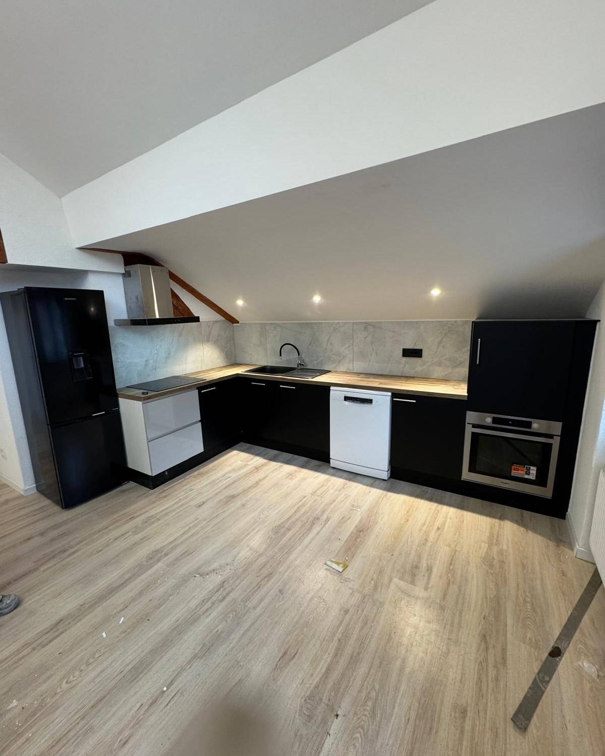 Cuisine ouverte avec carrelage sombre et mobilier laque noir