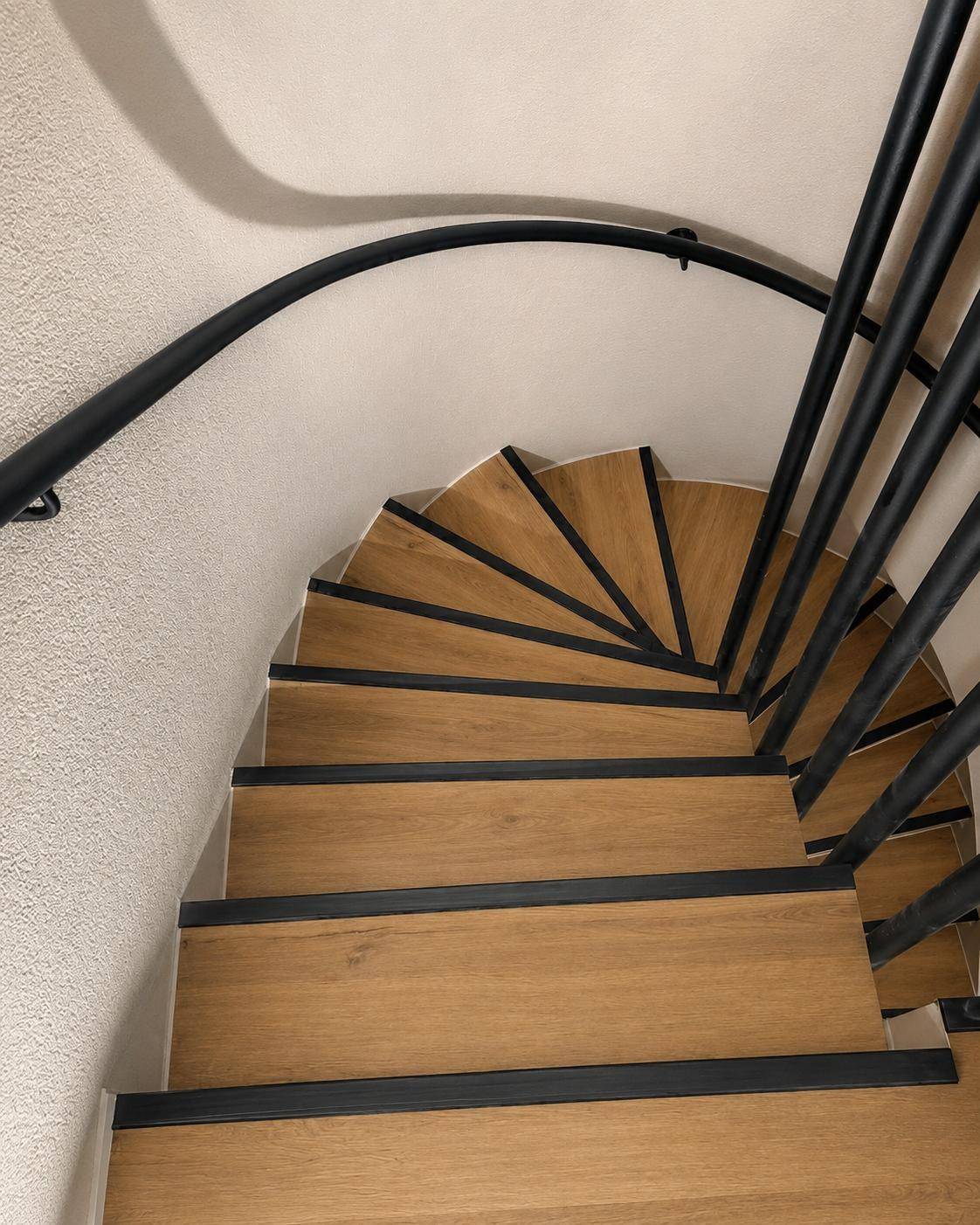 Vue plongeante d'un escalier helicoidal habille en chene, effet eventail sur les marches balancees