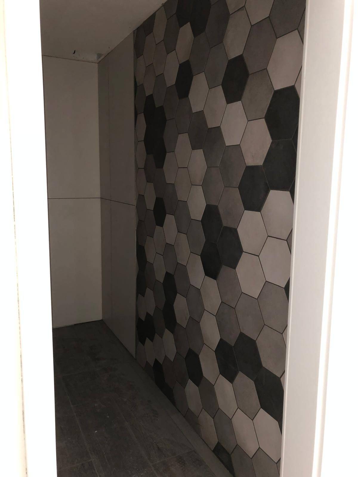 Mur interieur habille de carreaux hexagonaux anthracite, effet geometrique fort
