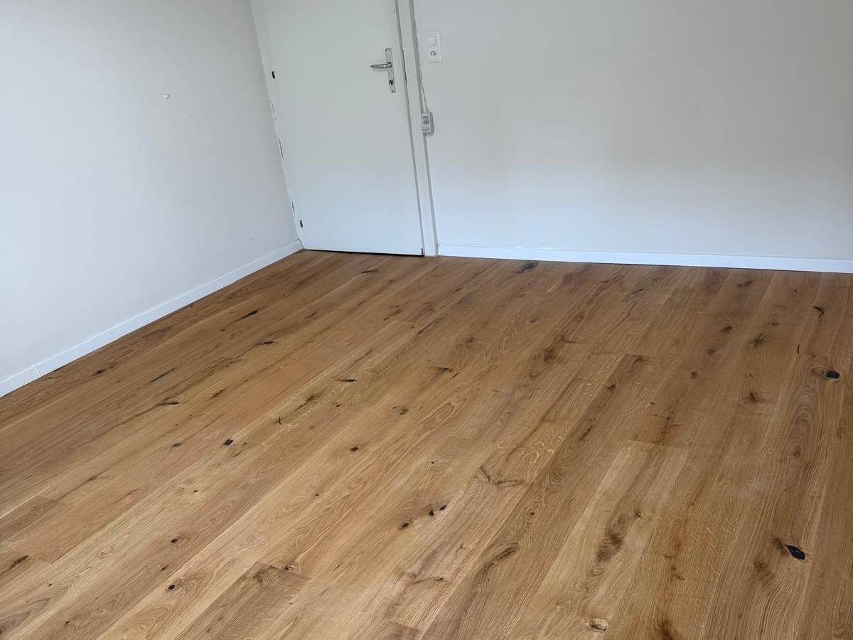 Parquet chene massif pose plein cadre dans une piece renovee, laves larges a noeuds apparents