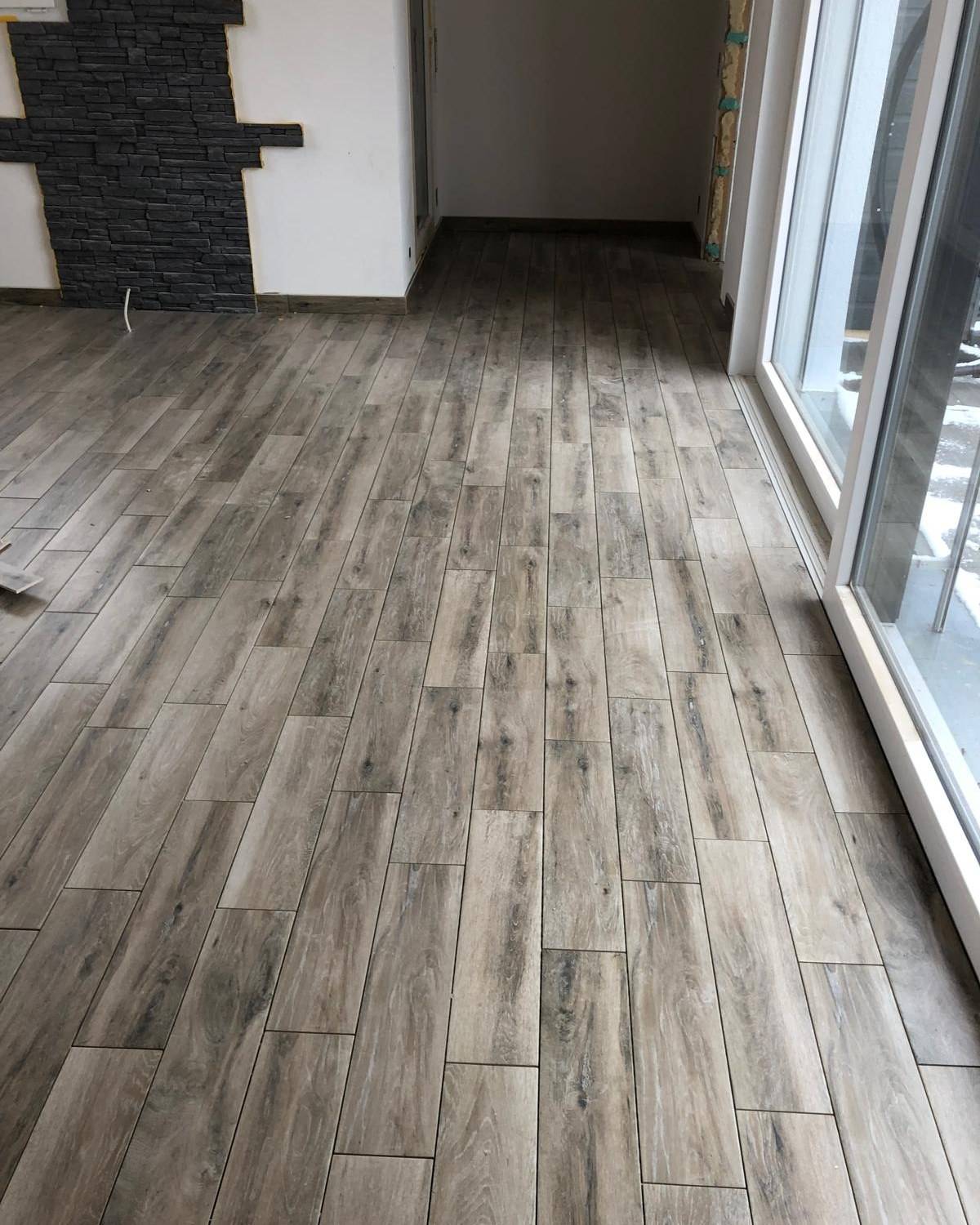 Piece avec carrelage grand format effet bois et mur d'accent en pierre ardoise