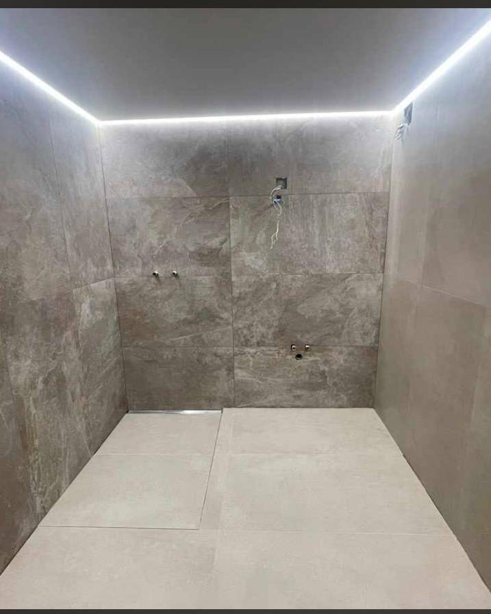 Salle de bain avec carrelage grand format et vasque suspendue